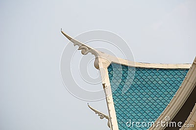 Small finials jutting out of the side â€“ corners of the blue gable roof, representing the heads of naga. Stock Photo